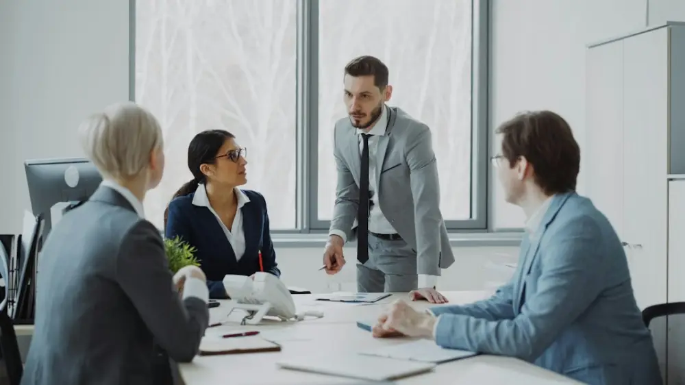 Business professionals in a meeting around a table, illustrating management professional certification